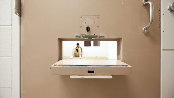 Peering through a food tray hole to see a youth in a solitary cell. © Richard Ross www.juvenile-in-justice.com
