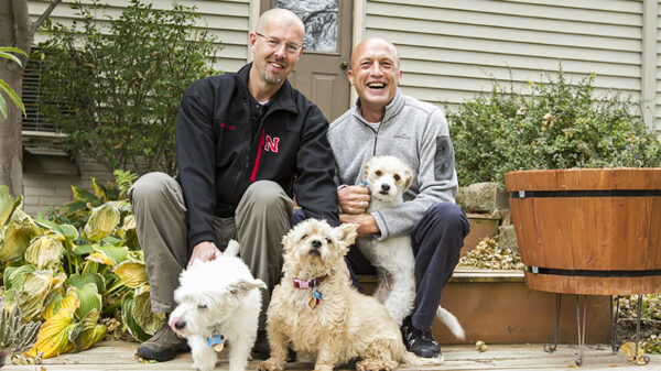 Todd and Joel outside of their home with their dogs.