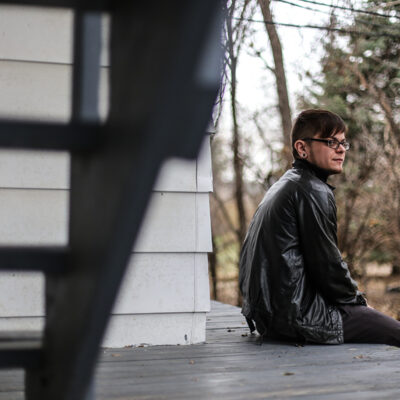 Dylan sitting on his porch outside of his home.