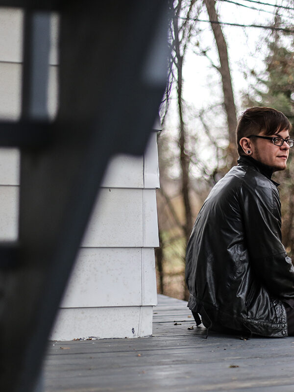 Dylan sitting on his porch outside of his home.