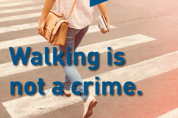 Woman walking down street with text "walking is not a crime"