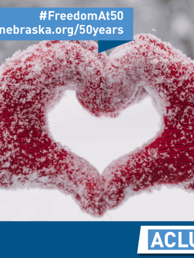 Photo of red gloovers, govered with snow, forming a heart