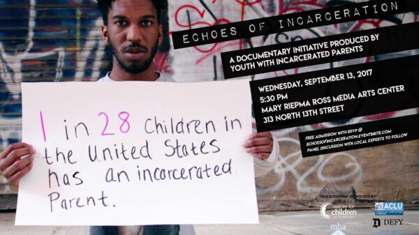 Photo of Man Holding Sign saying "1 in 28 children in the US has an incarcerated parent."