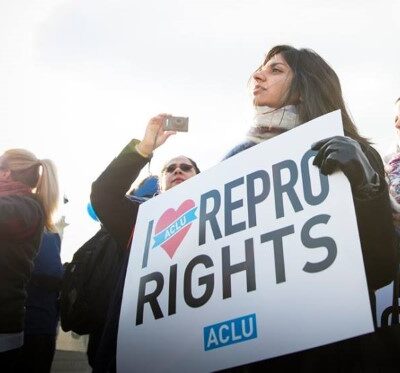 A woman holds a sign reading "I love repro rights."