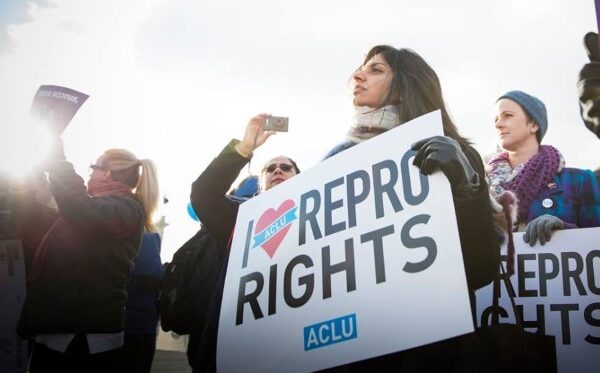 A woman holds a sign reading "I love repro rights."