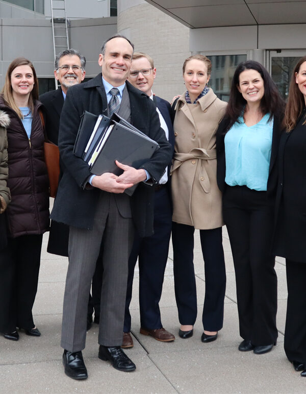 The legal team stands in front of the Roman L. Hruska Federal Courthouse.