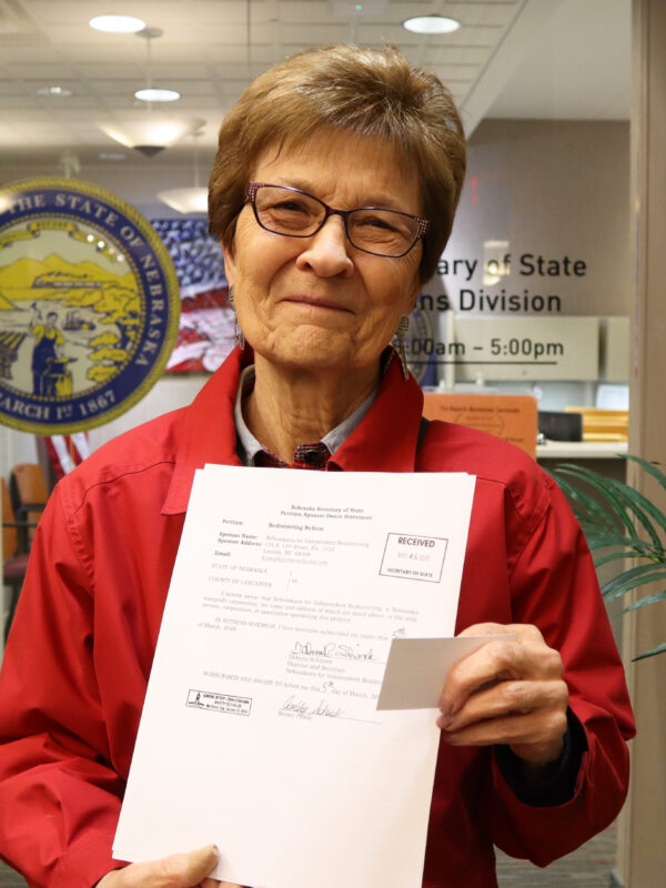 Campaign co-chair and former State Sen. DiAnna Schimek displays a copy of filed paperwork outside of the Nebraska Secretary of State’s Office.