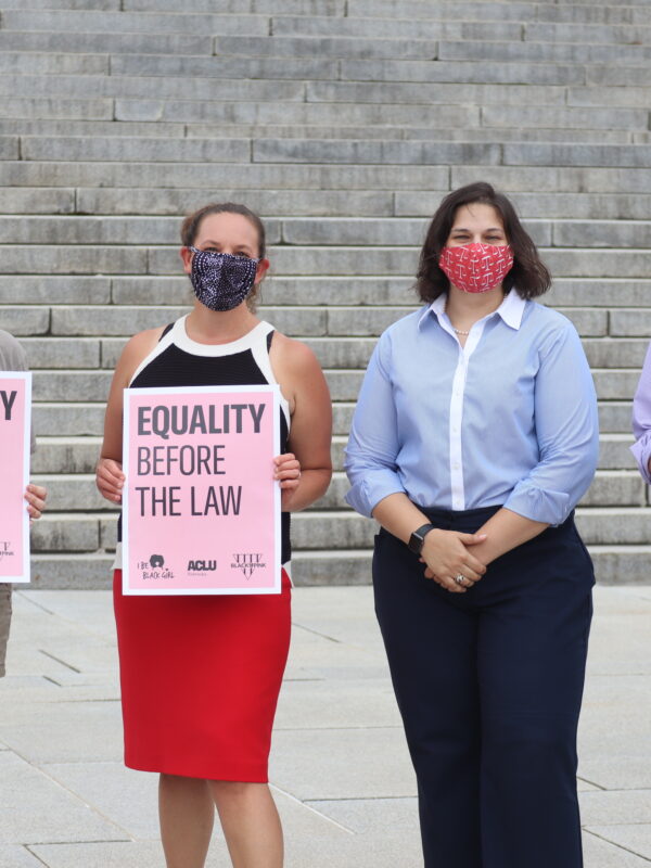 Four ACLU staff members stand outside the Nebraska State Capitol, three of whom are holding signs reading "Equality Before the Law."