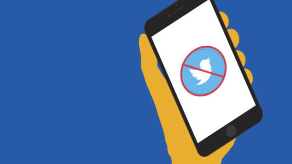 A graphic depicting a hand holding a phone with a red "X" over the Twitter icon.
