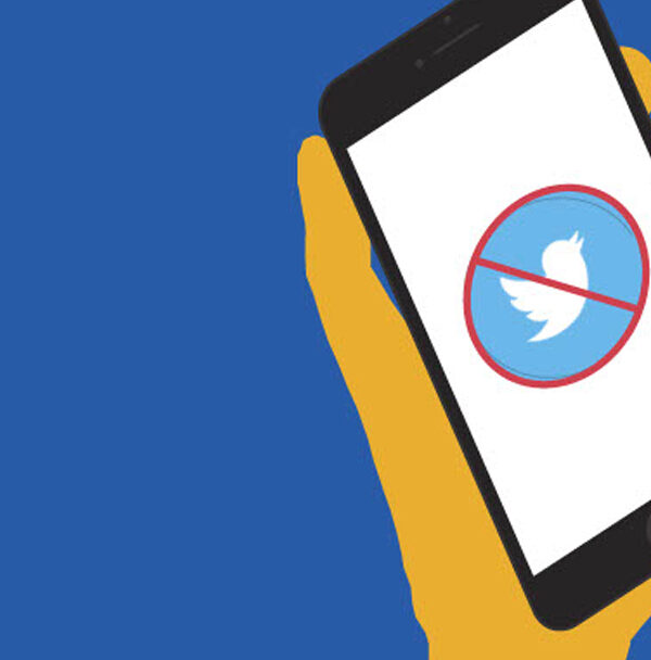 A graphic depicting a hand holding a phone with a red "X" over the Twitter icon.