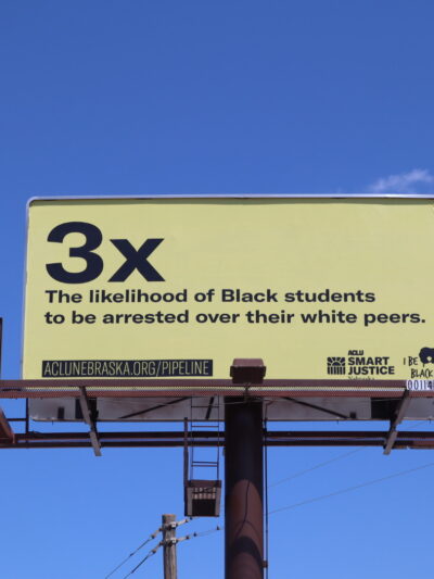 An Omaha billboard explains that Black Nebraska students are 3x more likely to be arrested than their white peers.