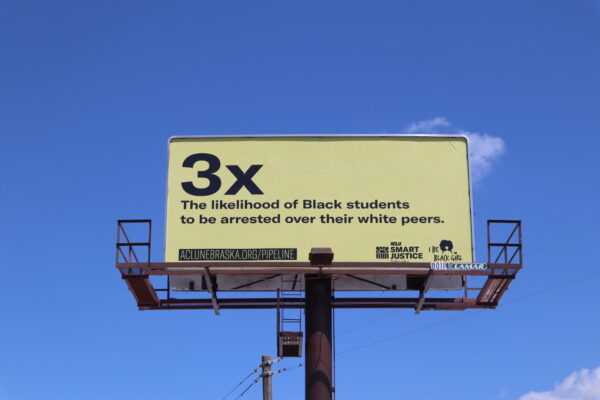 An Omaha billboard explains that Black Nebraska students are 3x more likely to be arrested than their white peers.