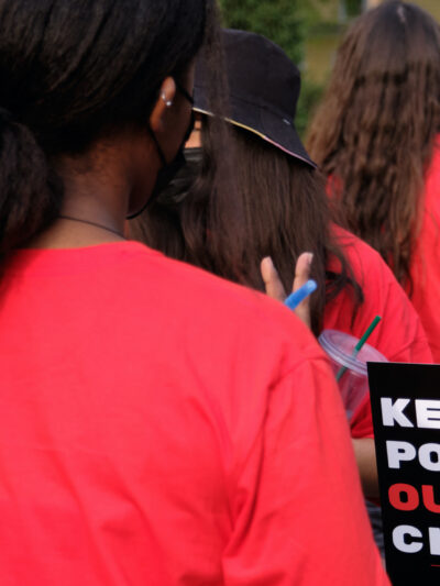 Students speak together at a rally before the University of Nebraska Board of Regents meeting. One holds a sign reading "Keep politics out of our classrooms."