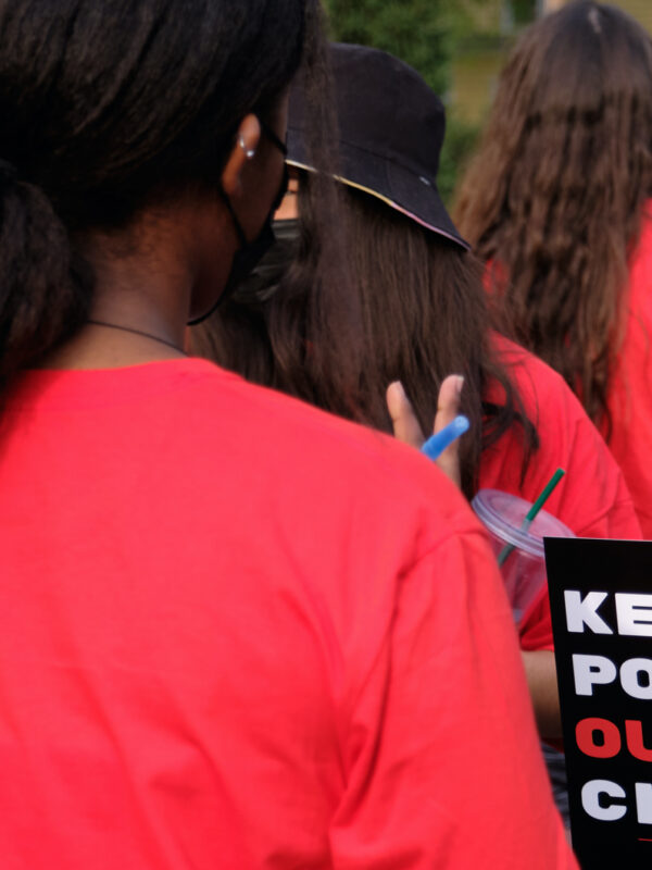 Students speak together at a rally before the University of Nebraska Board of Regents meeting. One holds a sign reading "Keep politics out of our classrooms."