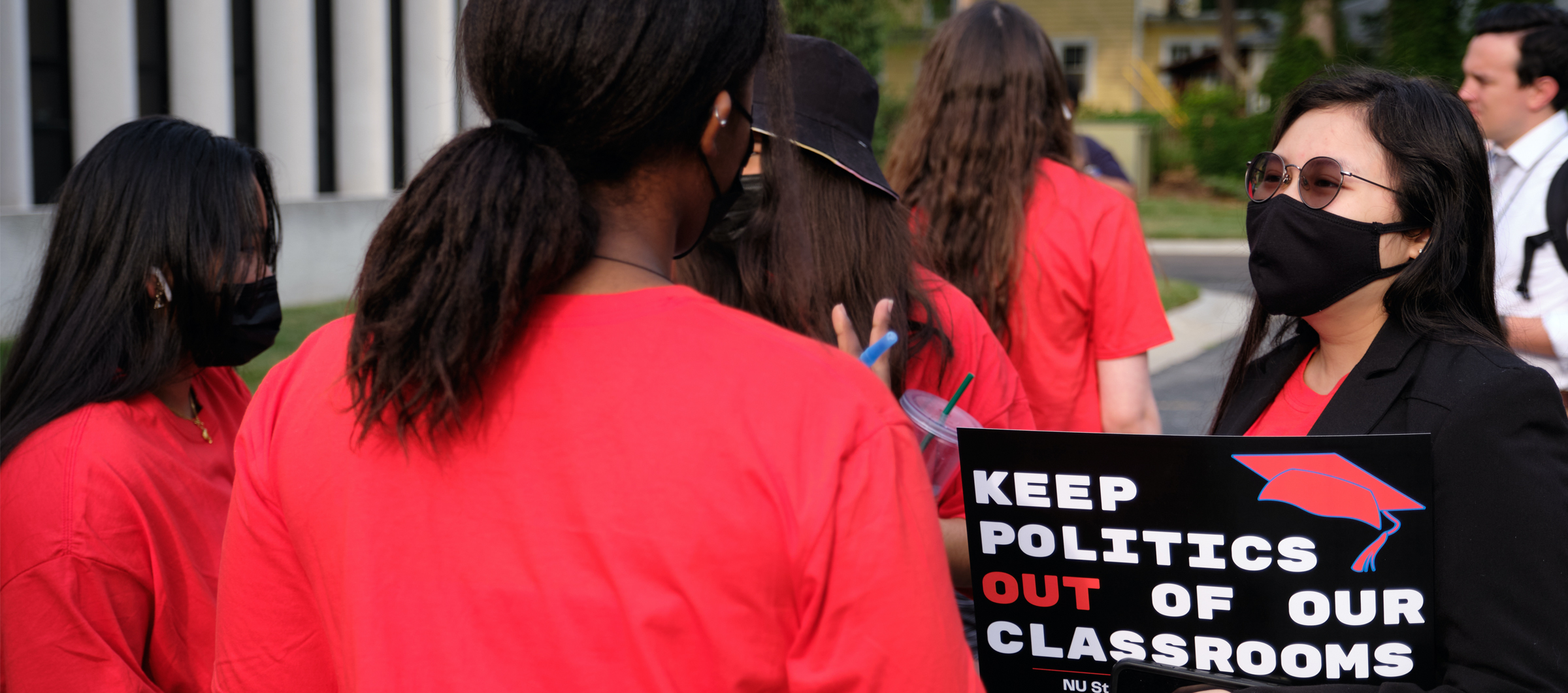 Students speak together at a rally before the University of Nebraska Board of Regents meeting. One holds a sign reading "Keep politics out of our classrooms."