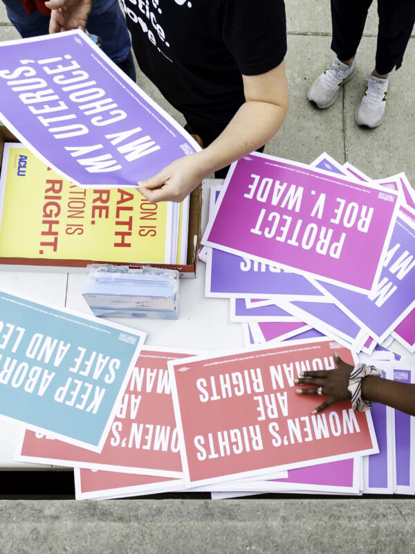 Reproductive justice rally attendees grab posters in Lincoln.