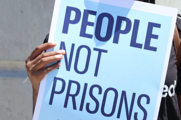 A poster reads "people not prisons"