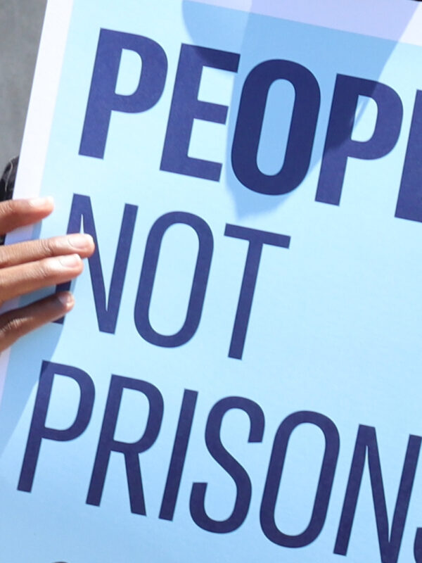 A poster reads "people not prisons"
