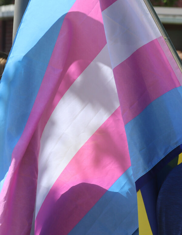A Nebraskan holds a trans pride flag at Hastings Pride.