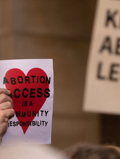 A Nebraskan holds a sign reading "Abortion access is a community responsibility"