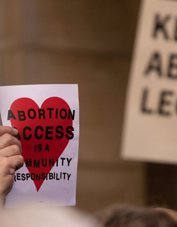 A Nebraskan holds a sign reading "Abortion access is a community responsibility"