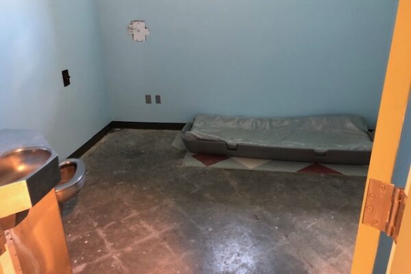 A photo taken at the YRTC in Geneva in the summer of 2019 shows a mattress on the floor of a barren room and a combined toilet and sink in the corner.