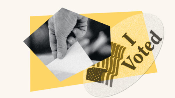 A hand holds a ballot next to a sticker reading "I voted."