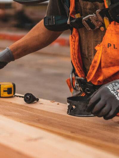 A construction worker reaches for a drill bit. Image courtesy Jeriden Villegas.