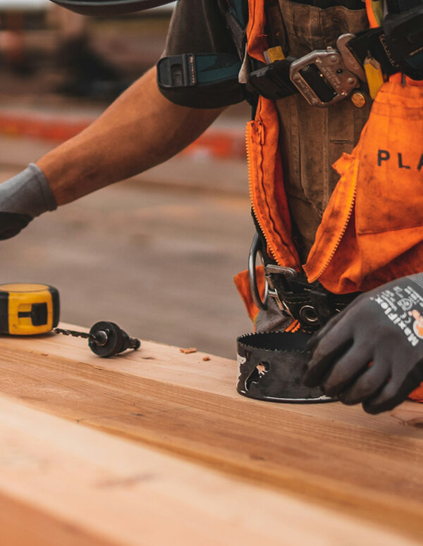 A construction worker reaches for a drill bit. Image courtesy Jeriden Villegas.