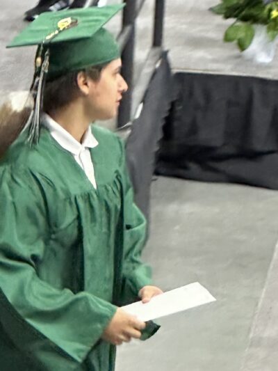 A young man walks off the stage during his high school graduation ceremony in Omaha.