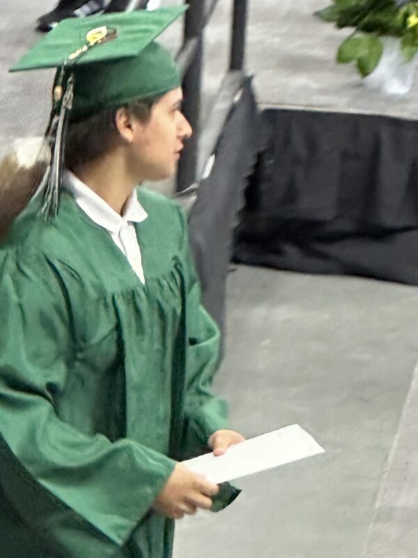A young man walks off the stage during his high school graduation ceremony in Omaha.