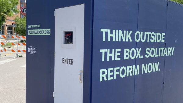 The ACLU of Nebraska's solitary replica cell reads "Think outside the box. Solitary reform now."