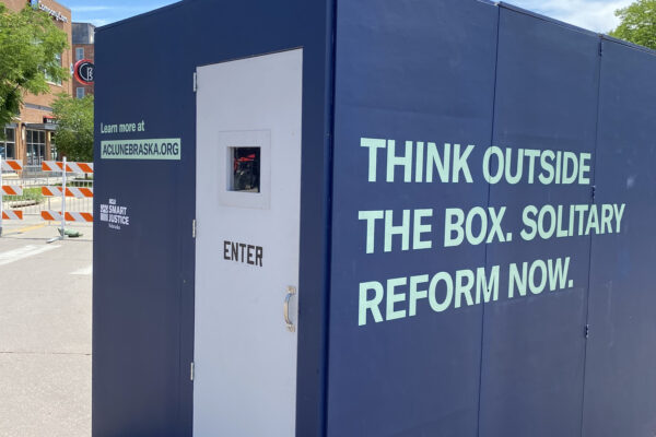 The ACLU of Nebraska's solitary replica cell reads "Think outside the box. Solitary reform now."