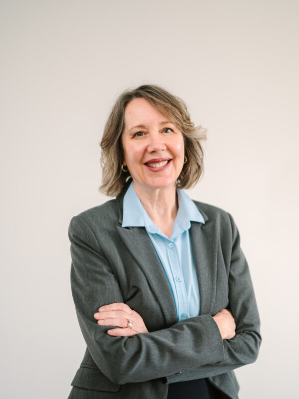 Development director Kristine Morton poses for a photograph in a light blue shirt and gray blazer.