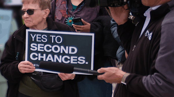A rally attendee holds a sign reading "yes to second chances."