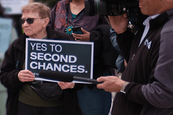 A rally attendee holds a sign reading "yes to second chances."