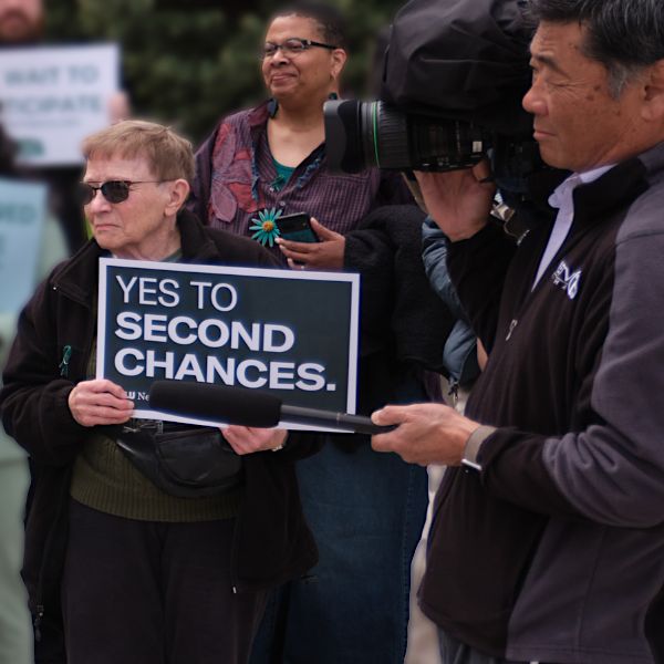 A rally attendee holds a sign reading "yes to second chances."