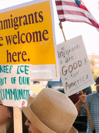 Rally attendees hold signs in support of immigrants at a demonstration outside the governor's mansion.