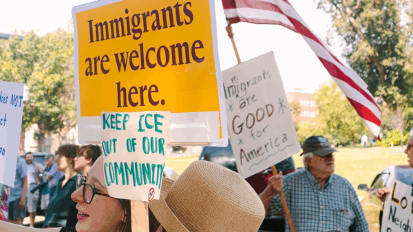 Rally attendees hold signs in support of immigrants at a demonstration outside the governor's mansion.