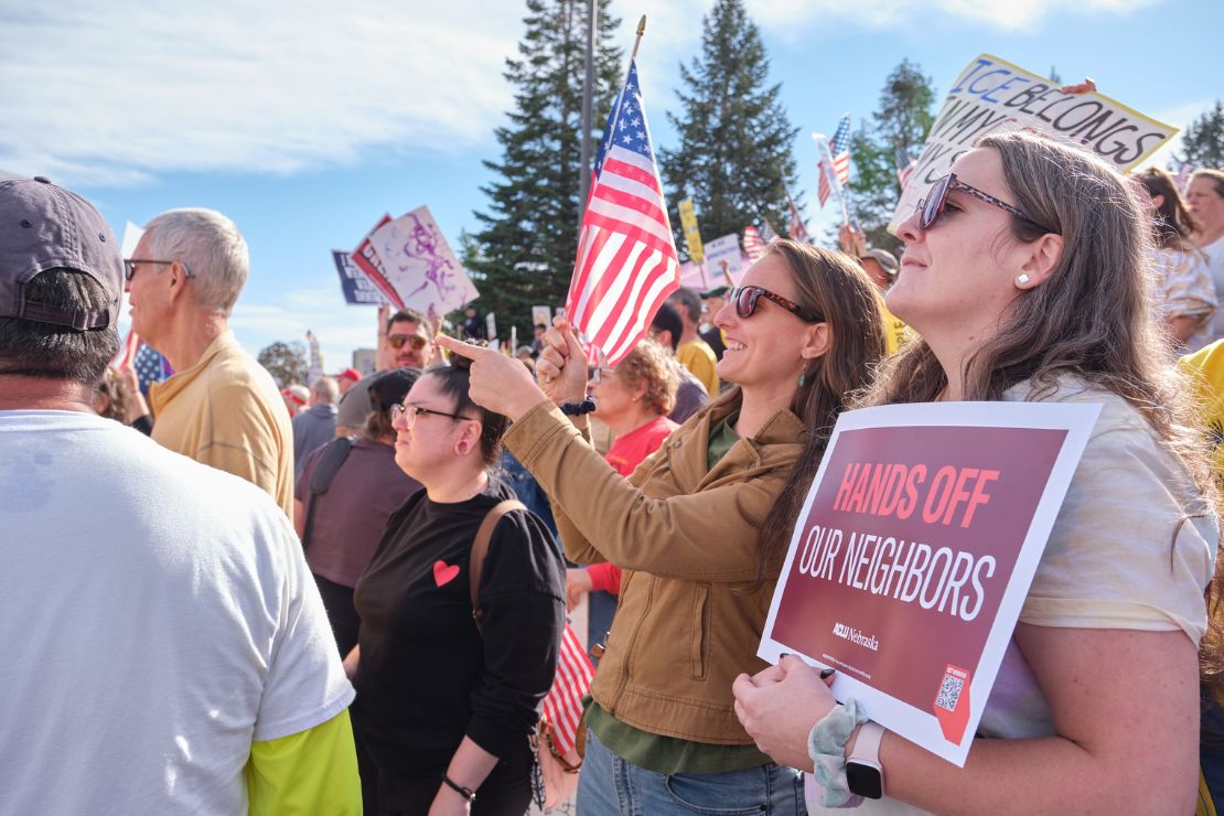 Nebraskans gather at a No Kings protest in Lincoln, NE in October of 2025. One holds an ACLU sign reading "Hands off our neighbors."