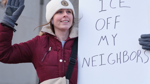 A protest attendee in Lincoln holds a sign reading "Keep ICE off my neighbors"