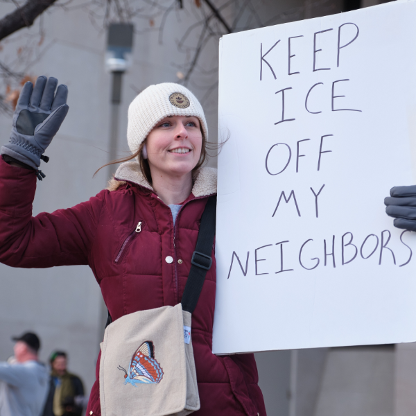 A protest attendee in Lincoln holds a sign reading "Keep ICE off my neighbors"