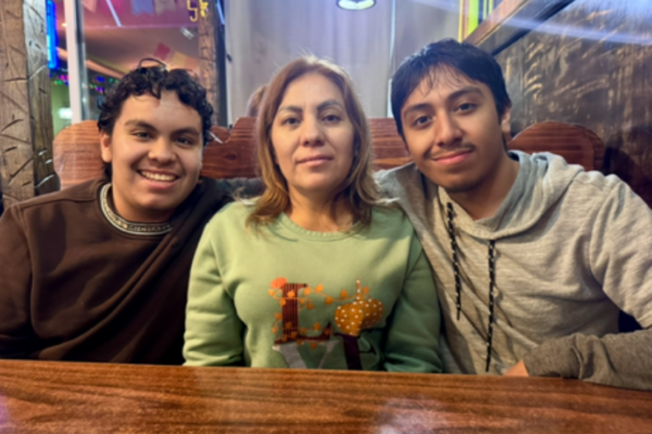 Lorena and her younger two sons Byron (left) and Emmanuel (right) pose for a photo at a celebratory dinner with their mother.
