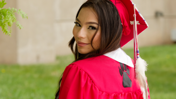 South Sioux City HS graduate Tiala Luong poses for a photograph in her gown and cap.