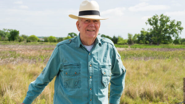W. Don Nelson leans against a fence by Lincoln's Saline Wetlands.