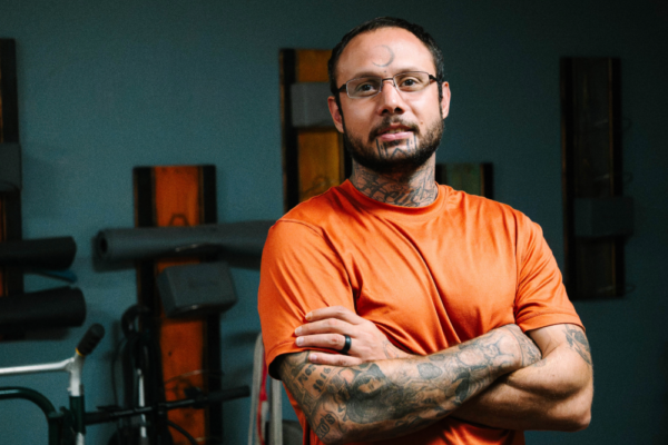 ACLU of Nebraska client Joshua Lewis looks at the camera with his arms crossed.