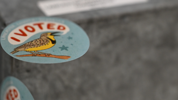 A ballot lock box includes a meadowlark sticker shouting "I Voted!"