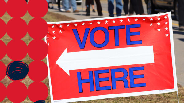 A yard sign reads VOTE HERE outside of a Nebraka polling place.