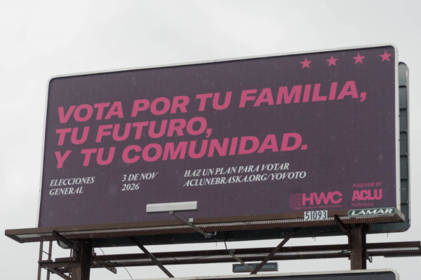 A billboard reads "vota por tu familia, tu futuro, y tu comunidad."