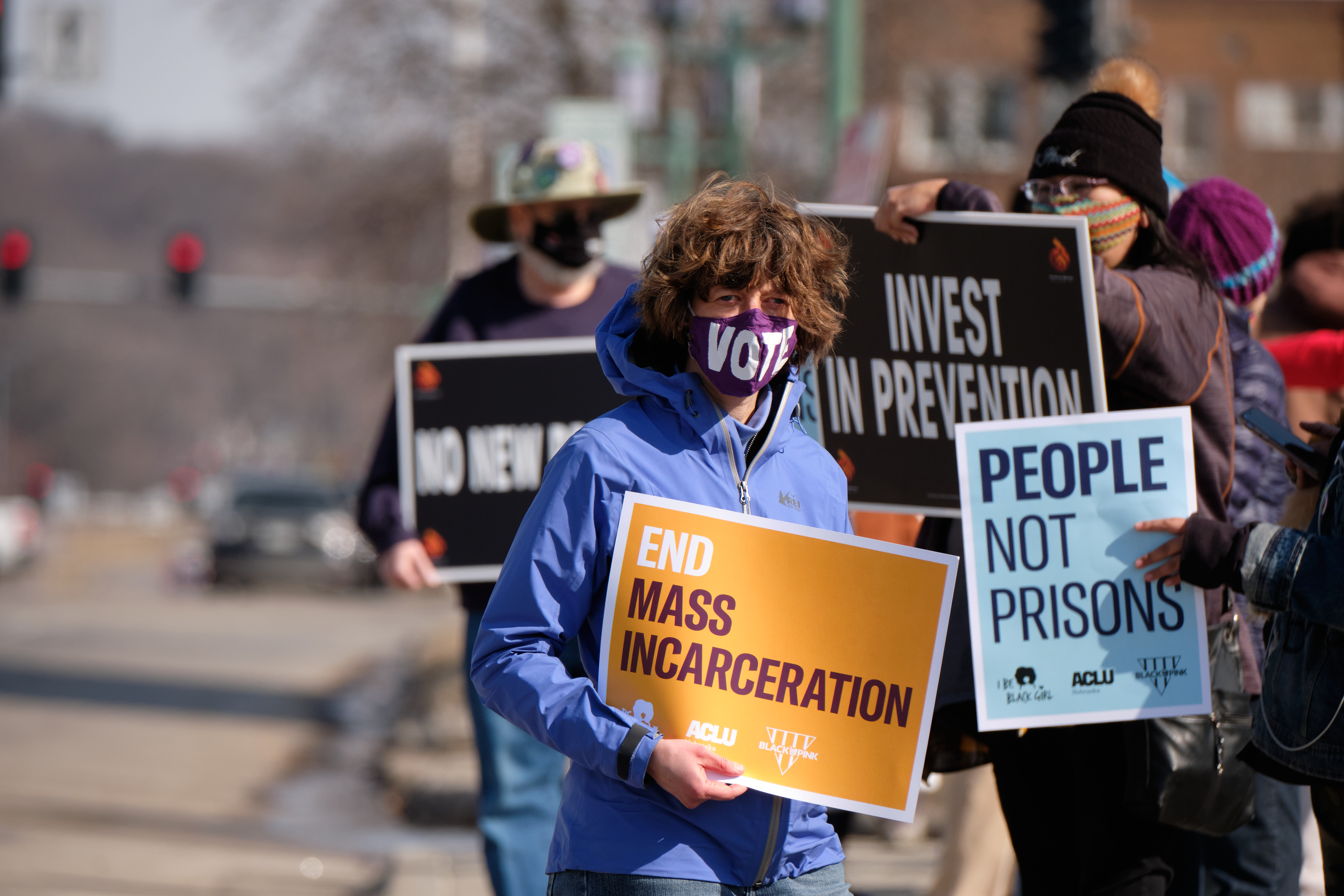 Protesters hold signs that read, "End Mass Incarceration," and "People Not Prisons."